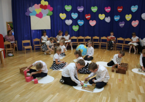 dzieci bawią się i uczą na dywanikach z pomocami